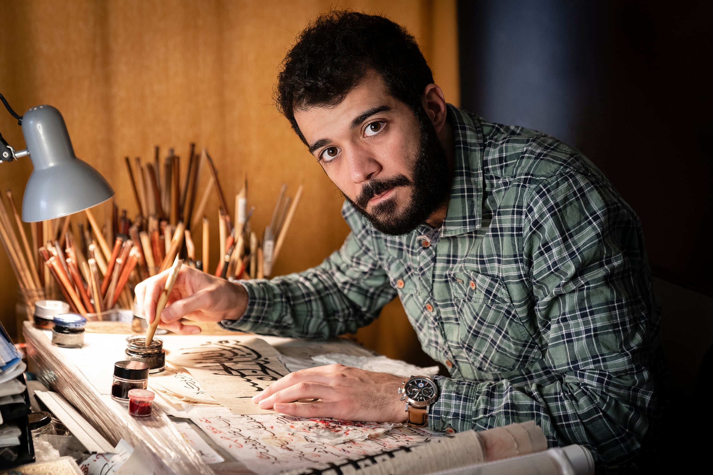 Mohammad Bandjaki practising calligraphy at his worktable