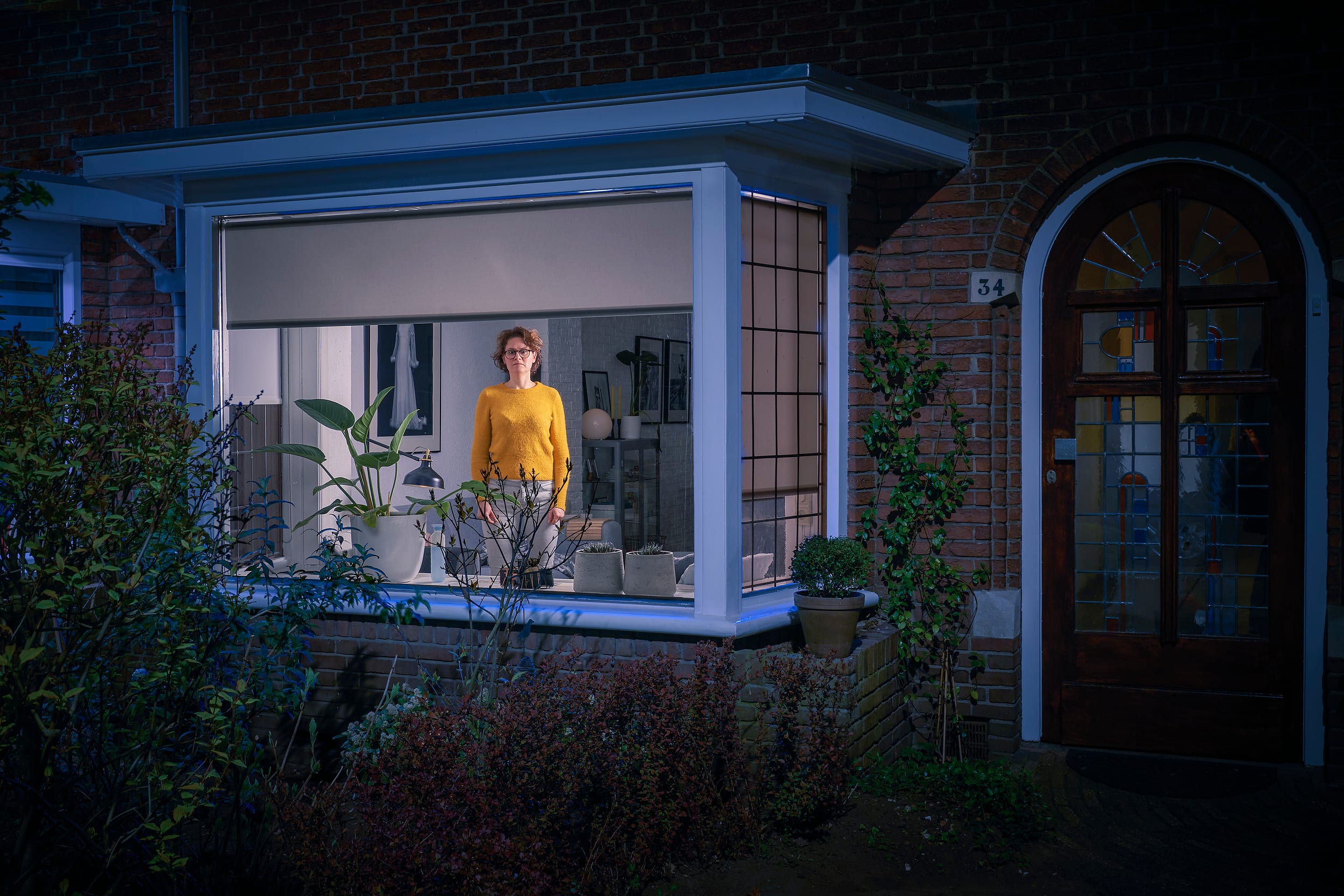 Saskia standing behind a window on the first day of lockdown