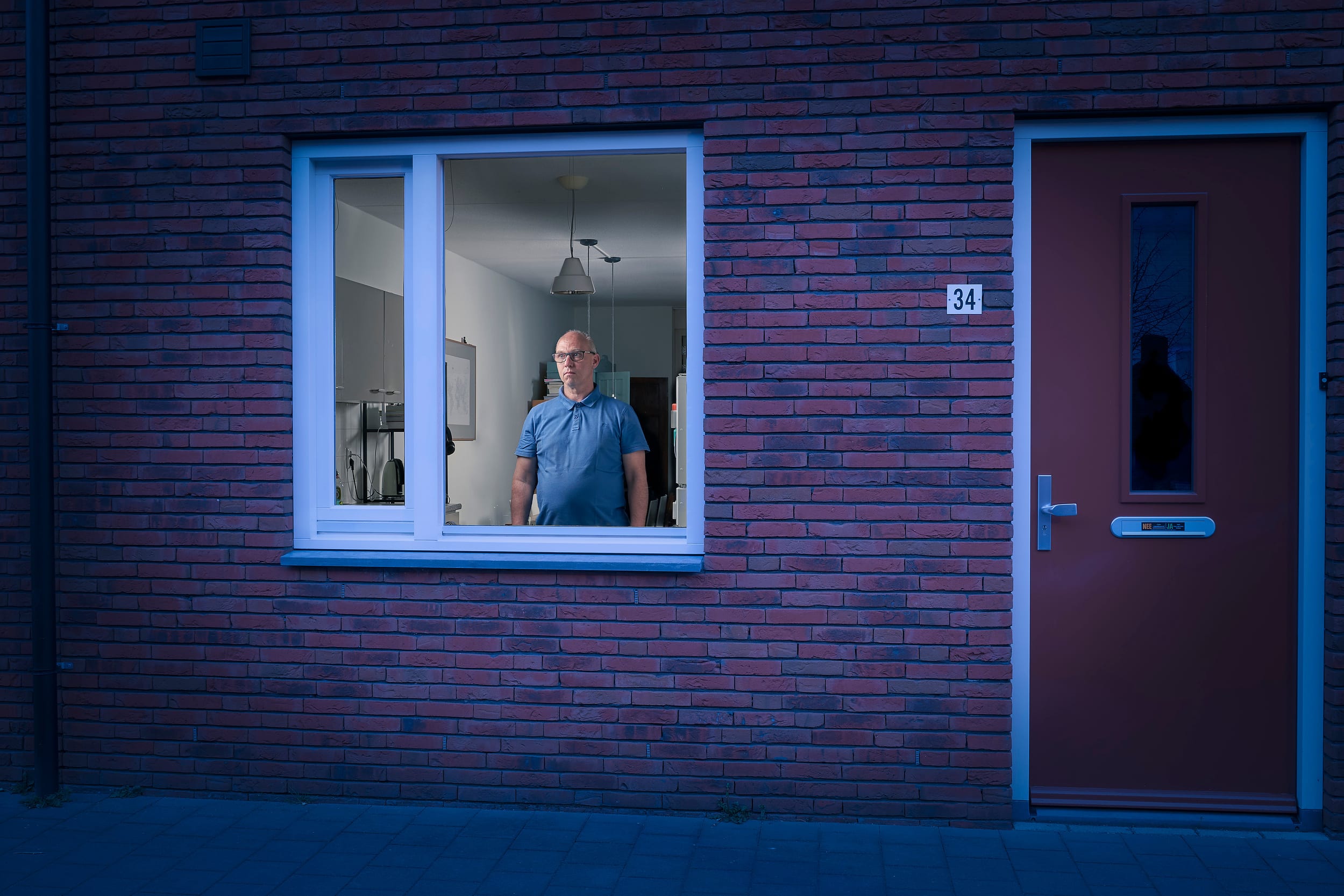 Arno standing behind the window of his home during lockdown